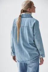 Sobrecamisa celeste de denim con bolsillos frontales con solapa y cierre abotonado.