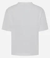 Remera de algodón color blanco, con cuello redondo y manga corta. Presenta un estampado con la frase 'Soy flor. Soy latina' y flores bordadas en relieve con textura tejida.