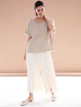 Pantalón palazzo color blanco con cintura alta y dos botones decorativos.