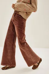 Pantalón de pana marrón, de corte wide leg, con tiro medio y bolsillos delanteros y traseros.