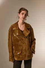Chaqueta tipo biker de gamuza sintética color tostado, con cuello solapa, cierre frontal y diseño holgado.