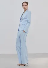 Pantalón de traje color celeste de tiro medio y diseño recto, con bolsillos laterales y cierre oculto.
