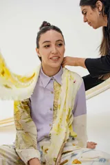 Pañuelo rectangular de tela fina color crema con estampado artesanal de hojas y flores en tonos amarillos y marrones.