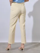 Pantalón de vestir color crema con finas rayas verticales en amarillo pálido. Tiene bolsillos simulados en la parte delantera y corte recto.