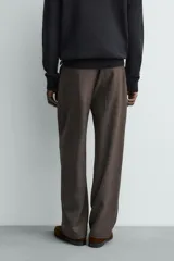 Pantalón straight fit color negro confeccionado en tejido con lana, con detalle de pliegues en el delantero, bolsillos frontales y traseros, y cierre frontal con cremallera y botón.