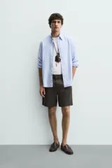 Bermuda regular fit azul marino confeccionada en lino, con bolsillos frontales, bolsillos traseros de doble vivo con botón y cierre frontal con cremallera y botón.