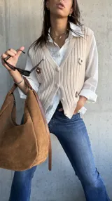 Chaleco de punto acanalado en color natural, con escote en V, cierre frontal con botones y detalles de flores bordadas en el frente.