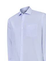 Camisa de manga larga para hombre, marca RKF línea Cityscape, en color celeste con un patrón de rayas verticales muy finas. Presenta un corte regular fit, cuello clásico, cierre frontal con botones blancos y un bolsillo en el pecho con el logo de la marca bordado.