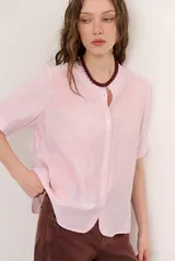 Camisa de manga corta color blanco con cuello mao y cierre frontal de botones. Presenta detalles bordados tono sobre tono en el canesú y diseño de corte recto.