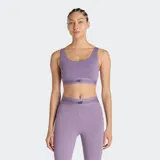 Top deportivo New Balance de impacto moderado, color violeta, con diseño de cuello redondo y banda elástica inferior con logo de la marca. Incluye copas extraíbles.