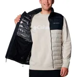 Chaleco Columbia Powder Lite II para hombre, con diseño bicolor en negro y beige. Presenta cierre frontal completo, cuello alto con protector de barbilla y bolsillos laterales con cierre. Cuenta con tecnología de aislamiento térmico y acabado resistente al agua.