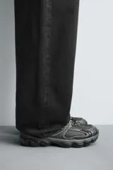 Zapatilla deportiva tipo running color blanco hueso con detalles en azul marino y amarillo flúor.