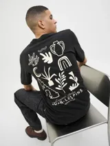 Camiseta negra de algodón con elastano, cuello redondo, manga corta y estampado en la espalda con diseños abstractos y texto "Originals Atelier JUAN-LES PINS JACK&JONES".