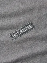 Remera Tommy Hilfiger de manga corta color gris, con cuello redondo y logo monotipo bordado en el parte izquierda del pecho. Incluye la bandera distintiva de Tommy Hilfiger bordada en la manga izquierda.