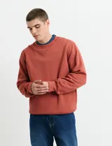 Sweater básico de cuello redondo y manga larga, confeccionado en tejido circular con puños y cuello en tejido canalé.