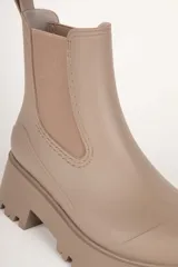 Botas Chelsea negras de caña baja, con elástico lateral y suela track.