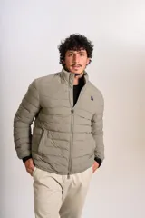 Campera puffer color beige con cierre frontal, cuello alto y logo de la marca bordado en el pecho.