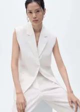 Chaleco tipo blazer sin mangas, de corte oversize y cuello con solapas. Confeccionado en lino, presenta un diseño abierto sin cierre y dos bolsillos laterales de ribete.