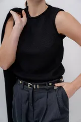 Chaleco negro tejido en alpaca, sin mangas y con cuello redondo. Corte recto y textura suave.