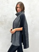 Poncho de lana gris con cuello alto y diseño de rayas verticales en dos tonos de gris.