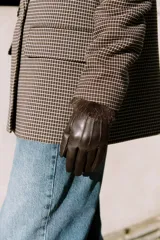 Guantes cortos de cuero sintético color marrón oscuro, con costuras decorativas en el dorso y puños con aplicación de pelo sintético a contraste.