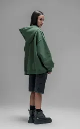 Hoodie oversize de corte crop, color verde, confeccionado en frisa gamuzada de algodón. Presenta capucha forrada y bolsillo canguro frontal.