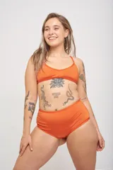 Conjunto de bikini verde esmeralda liso, compuesto por un corpiño triangular con breteles cruzados en la espalda y una bombacha clásica.