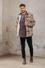 Sobrecamisa de corte holgado con diseño a cuadros en tonos azul marino y marrón, confeccionada con forro interior de corderito sintético, cuello clásico, cierre frontal de botones y bolsillos en el pecho.