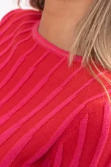 Buzo de punto acanalado con diseño de rayas verticales en tonos fucsia y rojo, de corte ajustado, cuello redondo y mangas largas ligeramente acampanadas.