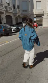 Camisa de jean celeste, de corte holgado, con cuello camisero, cierre frontal con botones y bolsillo de parche en el pecho.