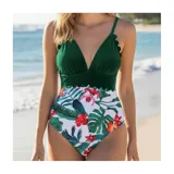 Malla enteriza bicolor de diseño combinado, con parte superior lisa en color negro de escote en V pronunciado con bordes ondulados, y parte inferior con estampado botánico de hojas verdes y flores rosadas sobre fondo negro. Cuenta con tirantes finos regulables.