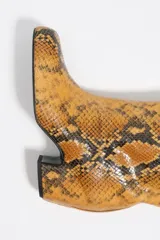 Bota alta de caña media con acabado en textura de piel de serpiente, diseño de puntera cuadrada y tacón bloque de altura media.