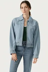 Campera de jean de corte corto con cierre frontal, cuello clásico y cintura con elástico. Presenta un diseño de hombros caídos y mangas amplias.