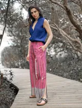 Pantalón de lino con estampado a rayas verticales en tonos celeste, verde, marrón y blanco.