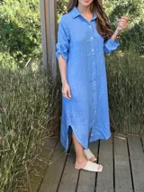 Vestido camisero largo de lino color azul celeste, con cuello camisero, botones frontales de nácar y aberturas laterales en el bajo.
