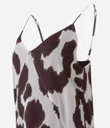 Vestido largo de corte evasé confeccionado en chiffon con estampado animal print. Presenta escote en V, breteles finos ajustables y diseño sin mangas. Incorpora una capa adicional en el ruedo que aporta movimiento y fluidez a la prenda.