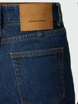 Pantalón de jean de corte acampanado, color azul oscuro, con tiro alto y bolsillos delanteros y traseros.