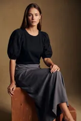 Remera negra de algodón con cuello redondo y mangas globo cortas confeccionadas en tela con detalle de broderie.