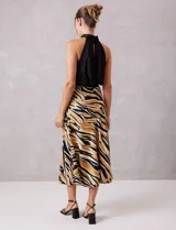 Falda midi de satén con estampado abstracto en tonos negro, beige y dorado. Presenta un corte fluido y cintura elastizada.