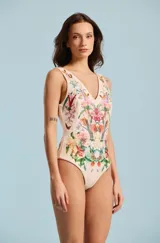 Body de mujer con escote en V y diseño ceñido, confeccionado con un llamativo estampado floral y de mariposas sobre base beige.