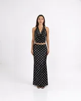 Top de satén con estampado de lunares, cuello drapeado y diseño halter con espalda descubierta.