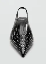 Zapato destalonado negro de tacón fino bajo, con punta fina y toda la superficie decorada con tachas plateadas pequeñas.