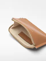 Monedero Adolfo Dominguez color ladrillo de cuero vacuno con cierre de cremallera, un compartimento y tarjetero en la parte trasera.