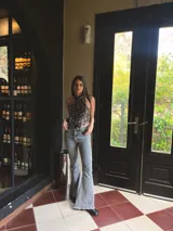 Jeans de corte flare y tiro medio, en color azul, con diseño acampanado y detalles de costuras en las piernas.