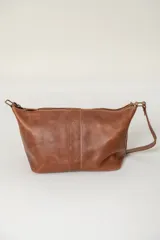 Neceser de cuero color marrón, con diseño estructurado, cierre superior y manija superior fija.