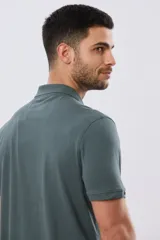 Remera polo de manga corta en color azul melange, con cuello camisero, cierre frontal de dos botones y pequeño bordado en el pecho.