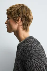 Jersey de corte relajado confeccionado en tejido de algodón con textura de trenzas. Presenta cuello redondo, manga larga y acabados en rib. Posee un efecto lavado que le otorga un aspecto único.