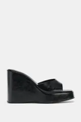 Sandalias de tacón tipo cuña alta con diseño estilo mule, color negro, con tira delantera ancha y puntera cuadrada.
