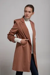 Saco blazer color beige con solapas de muesca, cierre frontal con dos botones, bolsillos laterales con solapa y corte recto.