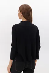 Polera de tejido de punto en color beige, con cuello alto y mangas largas con puños acanalados.